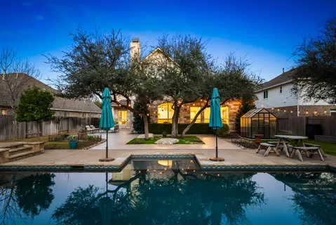a view of a house with pool and sitting area