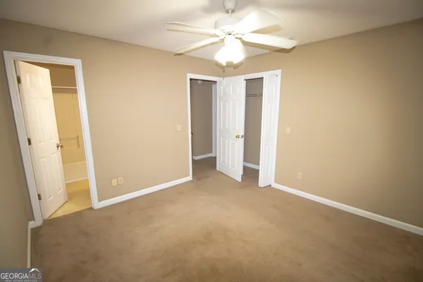 an empty room with a ceiling fan and a window
