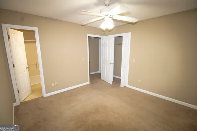 an empty room with a ceiling fan and a window