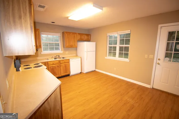 a view of a kitchen with a sink dishwasher and a refrigerator