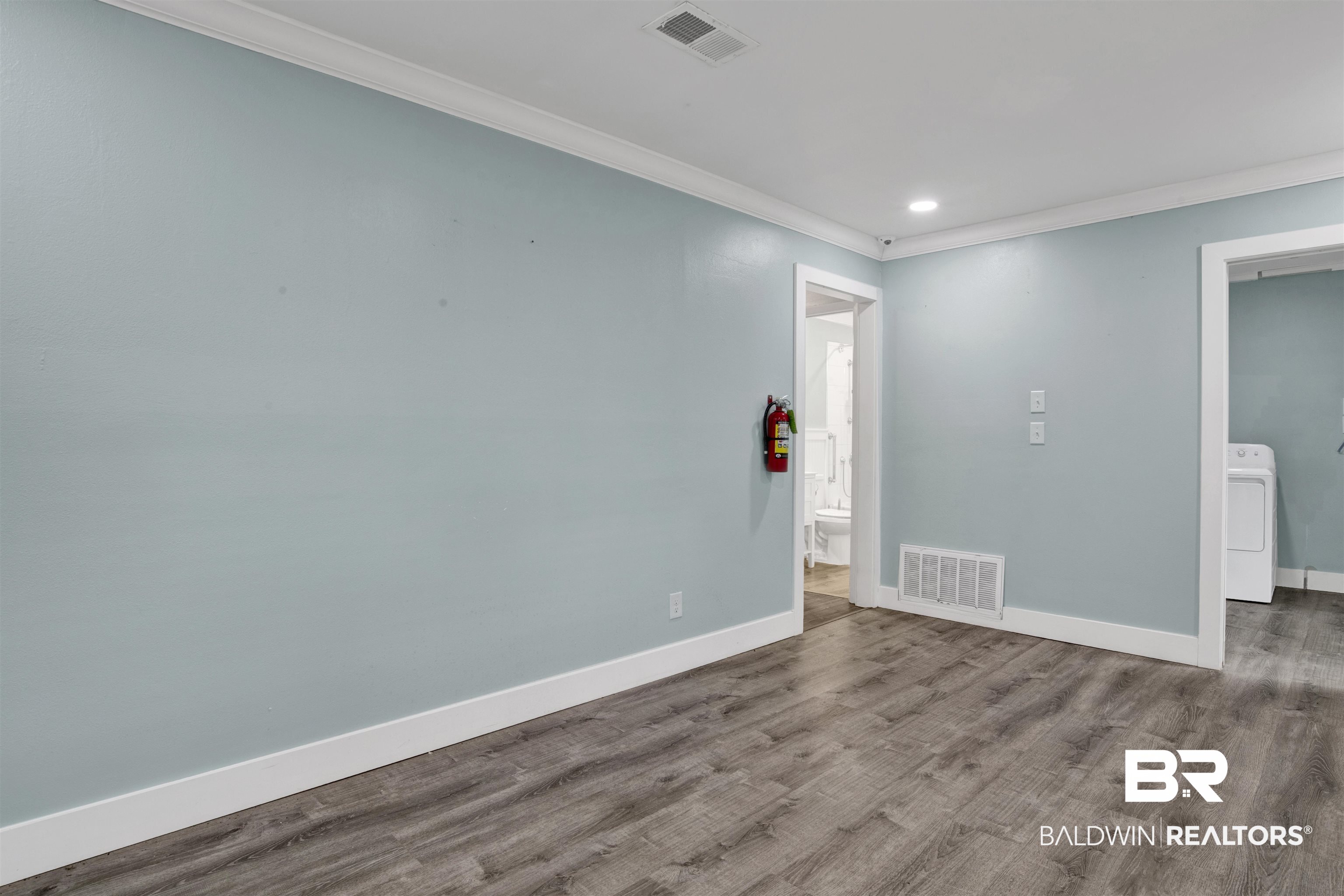 17714 Horseneck Road Bay Minette, AL 36507 - Photo 14 of 36 Spacious interior room with wood-finish flooring, light blue walls, and crisp white trim