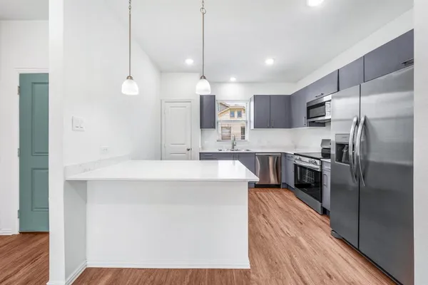 a kitchen with stainless steel appliances a refrigerator sink and stove