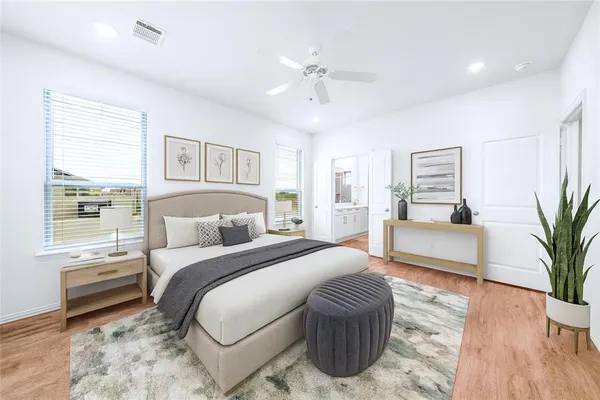a spacious bedroom with a large bed and a potted plant