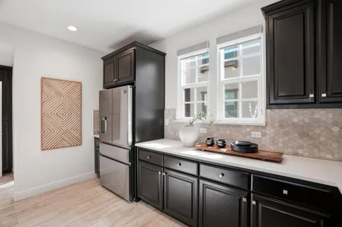 a kitchen with stainless steel appliances granite countertop a refrigerator and a sink