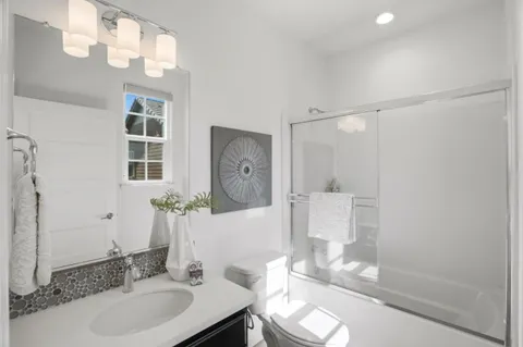 a bathroom with a granite countertop sink a toilet and shower