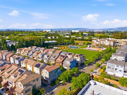 a view of a city with lots of residential buildings ocean and mountain view in back