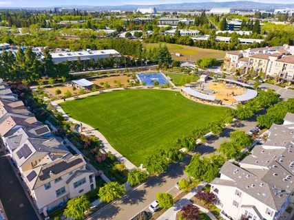an aerial view of a resort with swimming pool tennis courts and ocean view