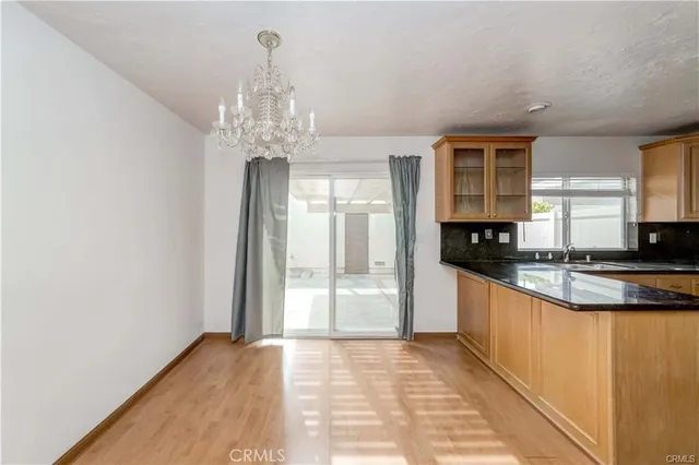 a large kitchen with granite countertop a stove and cabinets