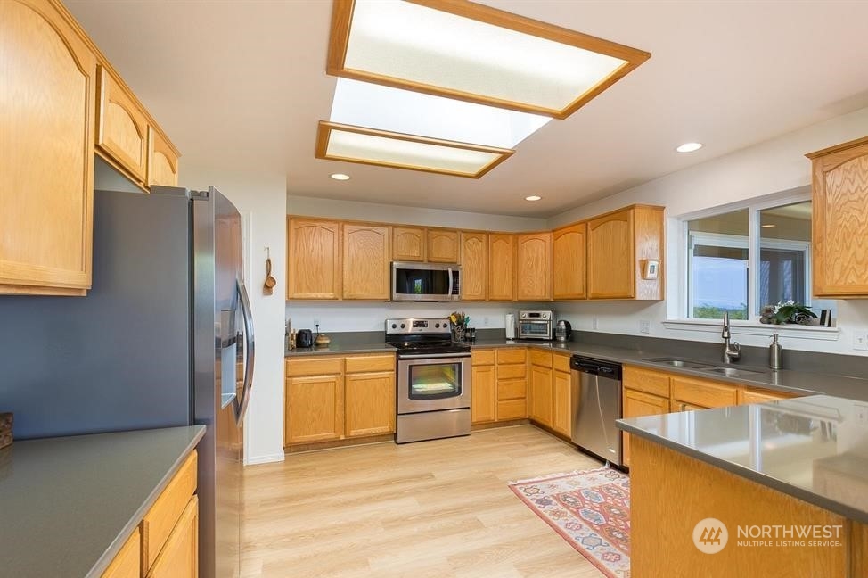 41 Onyx Lane Sequim, WA 98382 - Photo 17 of 40 a large kitchen with stainless steel appliances granite countertop a stove refrigerator and a sink