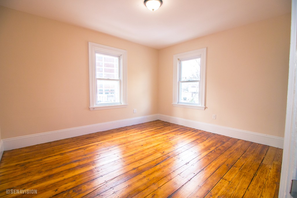 40 Humphreys Street Boston, MA 02125 - Photo 7 of 13 a view of an empty room with wooden floor and a window