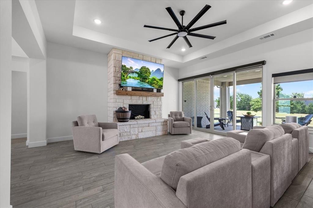 1039 Monaco Court Springtown, TX 76082 - Photo 5 of 33 Spacious living area featuring a floor-to-ceiling stone fireplace with a wood mantel