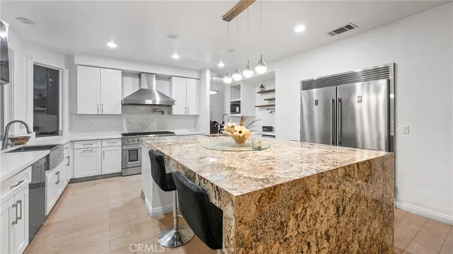 a spacious bedroom with a large bed a flat tv screen and a dresser