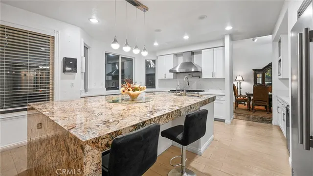 a spacious bedroom with a large bed a flat tv screen and dresser