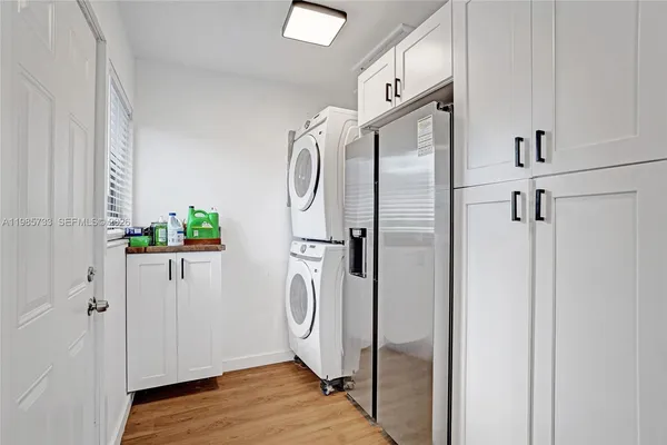 a white refrigerator freezer and a wooden floor