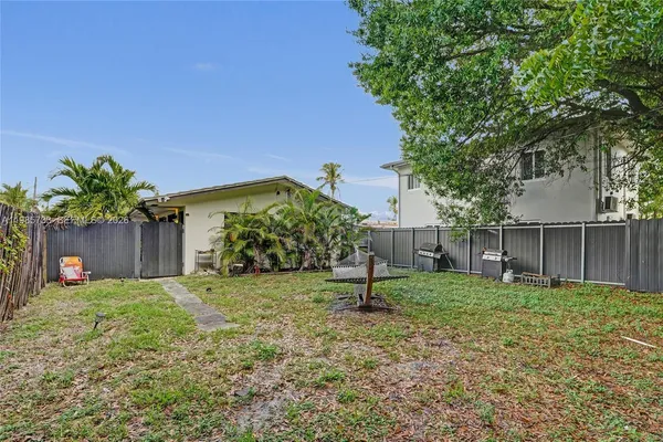 a view of a house with a yard and tree