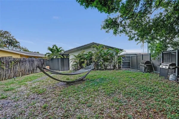 a view of a house with backyard and sitting area