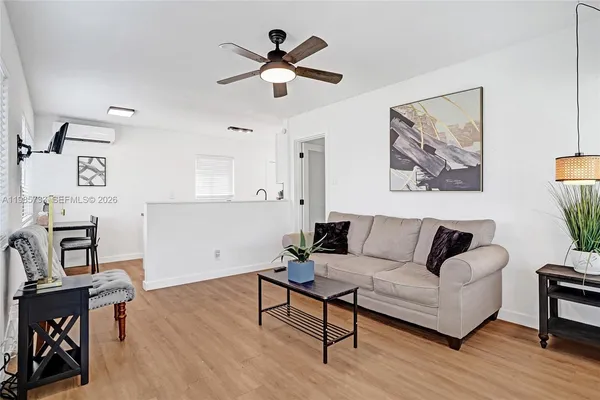 a living room with furniture and a wooden floor