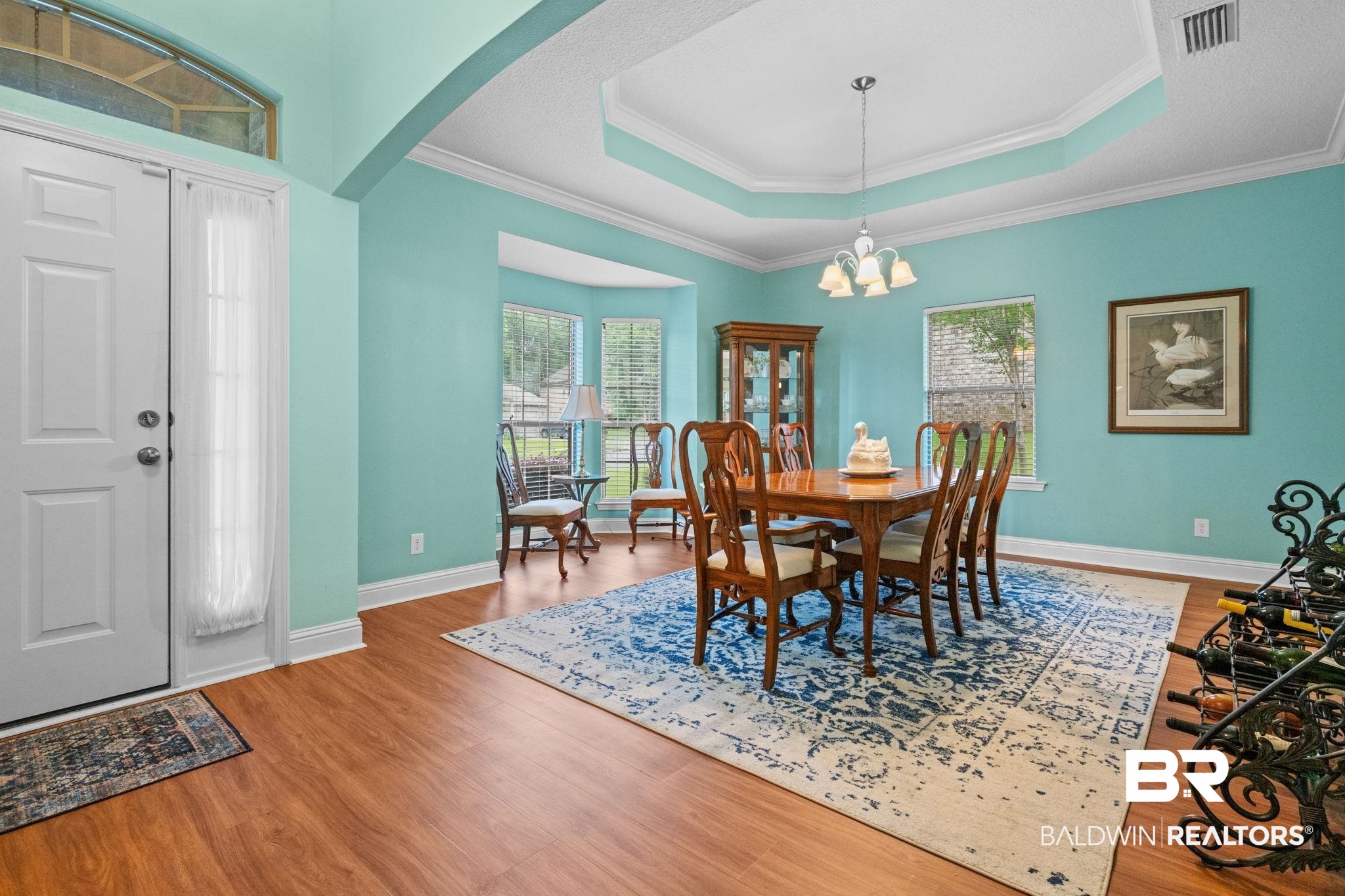 2554 Masters Court Mobile, AL 36618 - Photo 5 of 35 Dining room featuring a tray ceiling, arched walkways, wood finished floors, a chandelier, and ornamental molding
