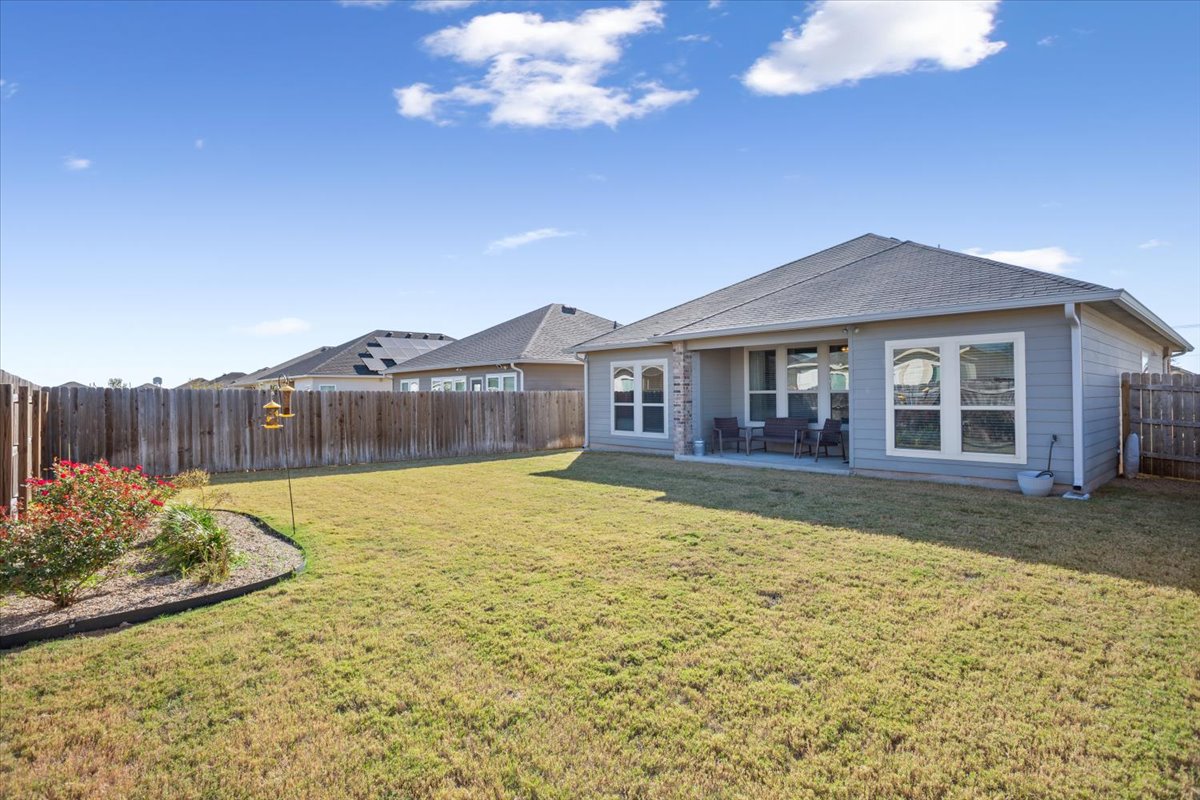 1149 Spring Terrace Loop Temple, TX 76502 - Photo 25 of 25 Rear view showcases the covered patio, large windows, and open yard — perfect for gatherings, gardening, or quiet relaxation.