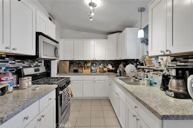 a kitchen with stainless steel appliances granite countertop a sink stove and cabinets