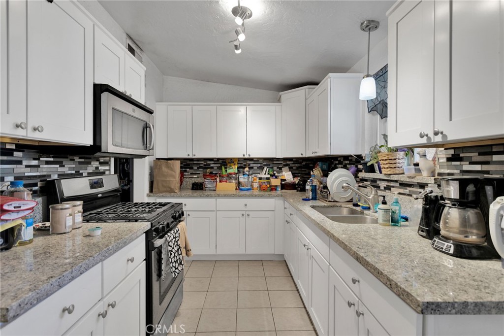 25488 Jade Road Barstow, CA 92311 - Photo 12 of 25 a kitchen with stainless steel appliances granite countertop a sink stove and cabinets
