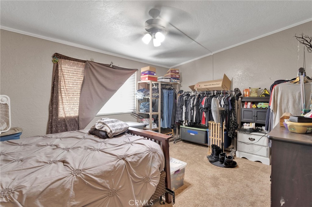 25488 Jade Road Barstow, CA 92311 - Photo 18 of 25 a bedroom with a bed and a walk in closet