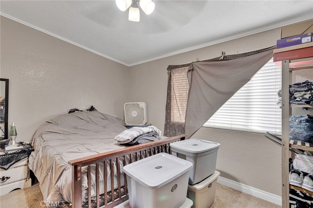 25488 Jade Road Barstow, CA 92311 - Photo 19 of 25 a bedroom with a bed and chandelier