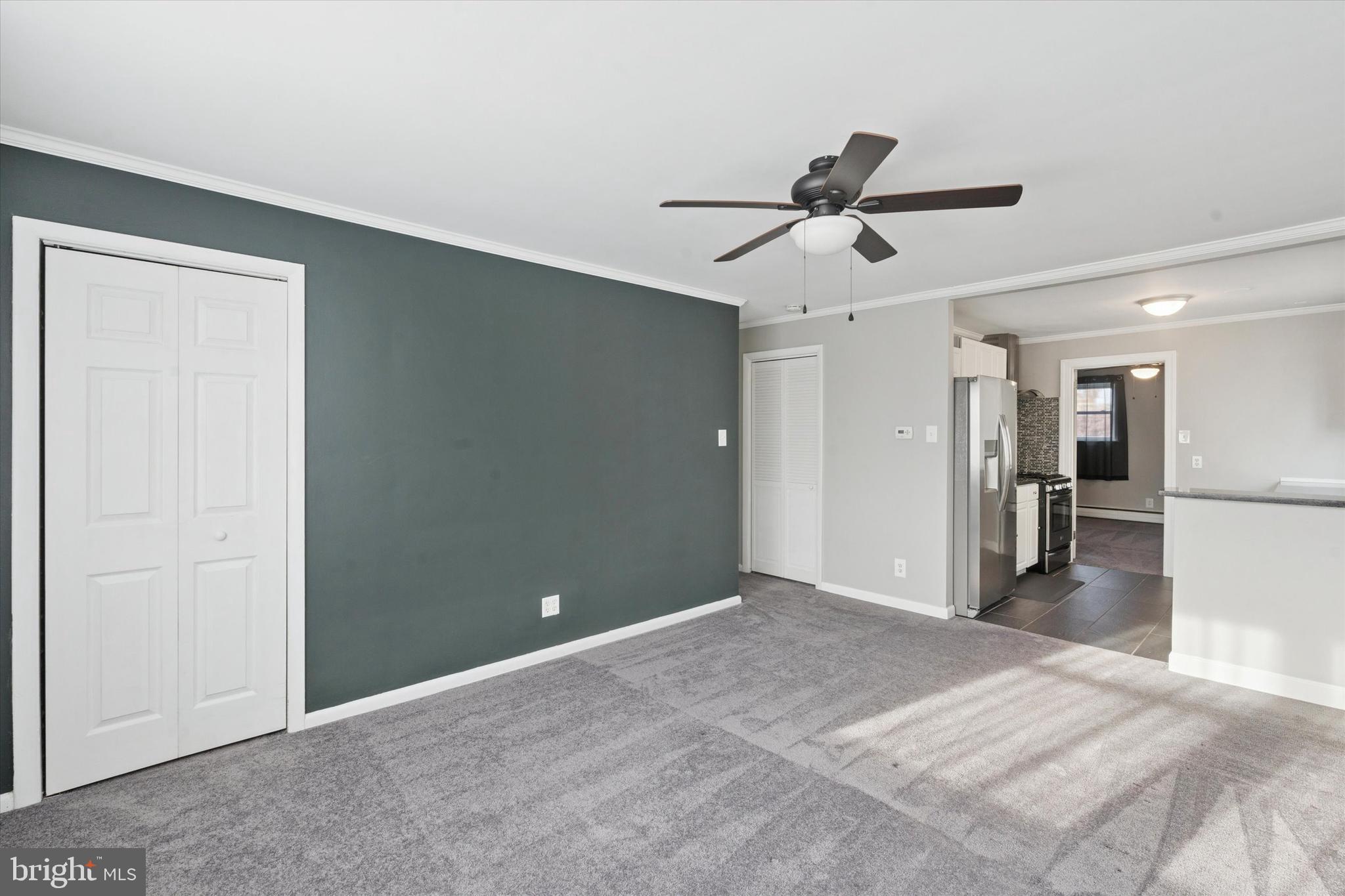703 Hoffnagle Street, Unit 2 Philadelphia, PA 19111 - Photo 5 of 15 a view of a livingroom with a ceiling fan & kitchen space