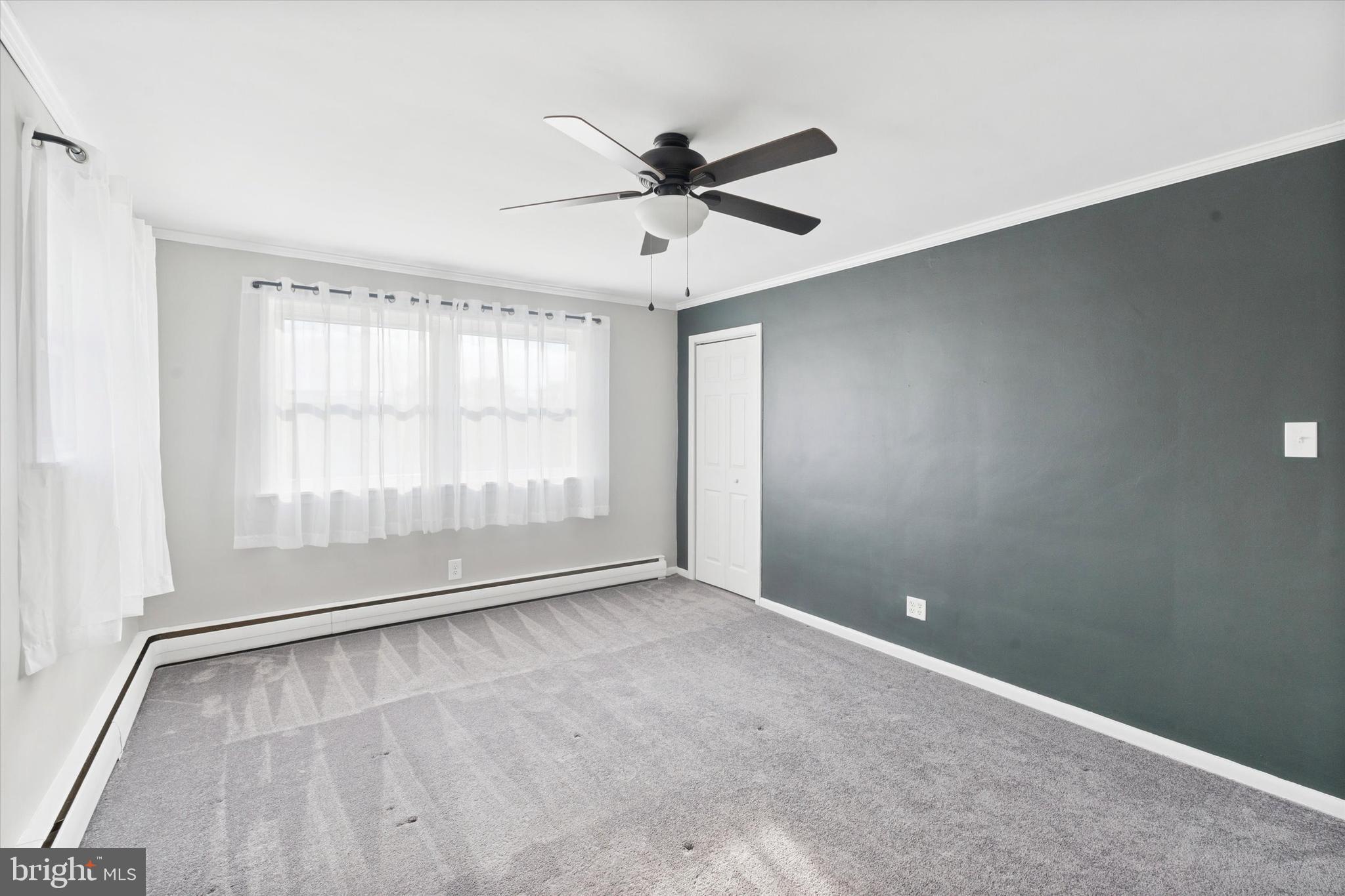 703 Hoffnagle Street, Unit 2 Philadelphia, PA 19111 - Photo 6 of 15 an empty room with wooden floor fan and windows