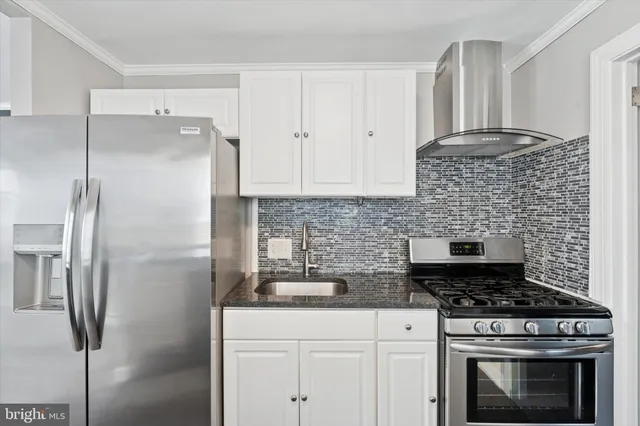 a kitchen with stainless steel appliances granite countertop a stove and a refrigerator