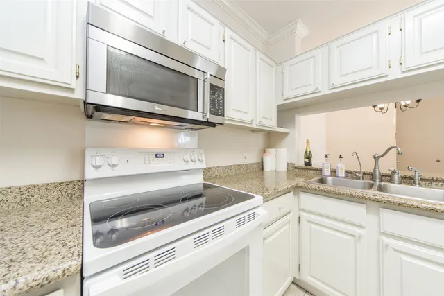 a kitchen with granite countertop stainless steel appliances and white cabinets