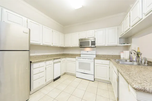 a kitchen with granite countertop cabinets and white appliances