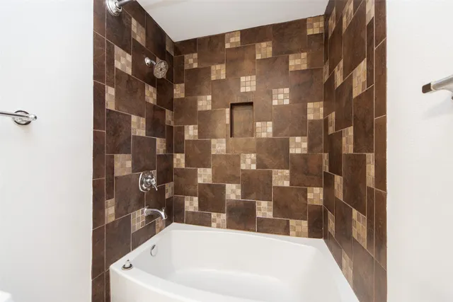 a bathroom with a bathtub and shower