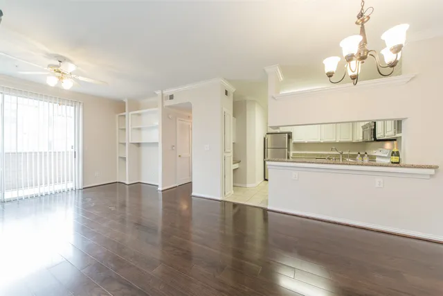 a view of a room with wooden floor and chandelier