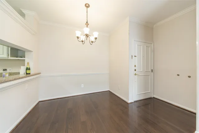 an empty room with wooden floor and sink