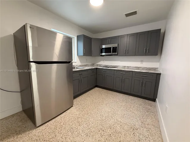 a kitchen with stainless steel appliances granite countertop a refrigerator and a sink