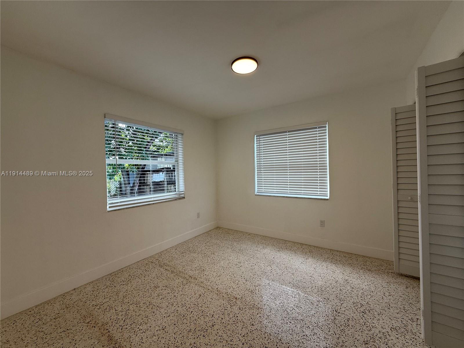 3146 Northwest 29th Street, Unit A Miami, FL 33142 - Photo 5 of 9 an empty room with windows