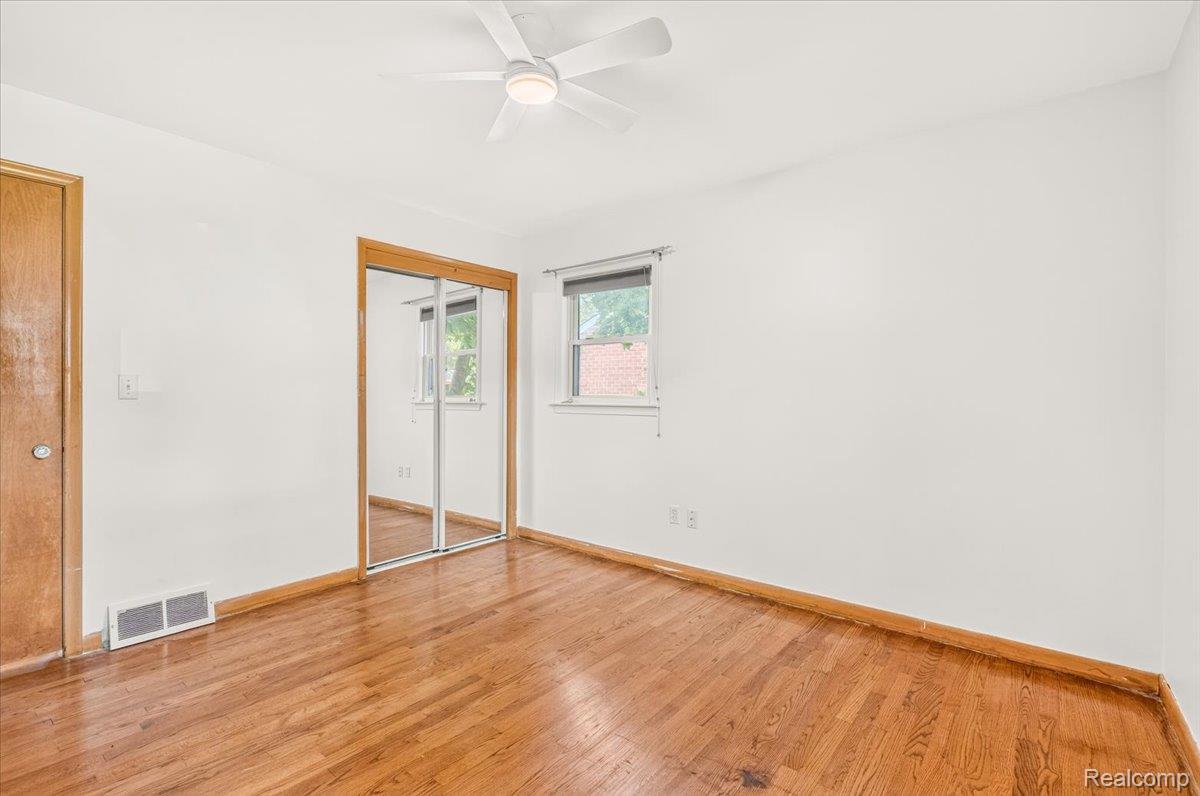 11802 Columbia Street Redford, MI 48239 - Photo 20 of 39 Bedroom 3 with Original Hardwood Floors in good condition, Vinyl Replacement Windows, a New Ceiling Fan, and Mirrored Closet Doors.