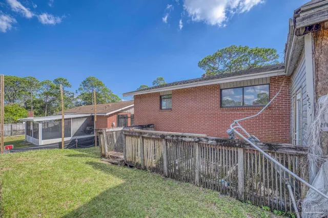 a view of a house with a yard and a wooden fence