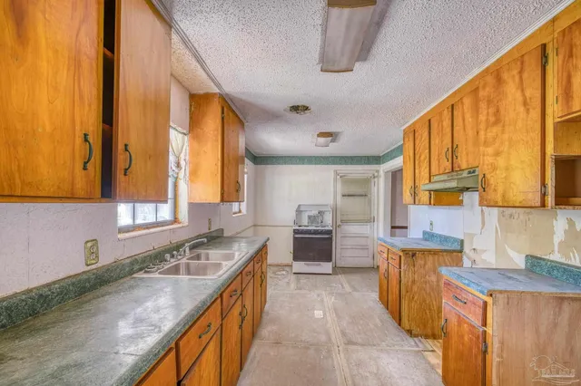 a kitchen with a stove a sink and a refrigerator