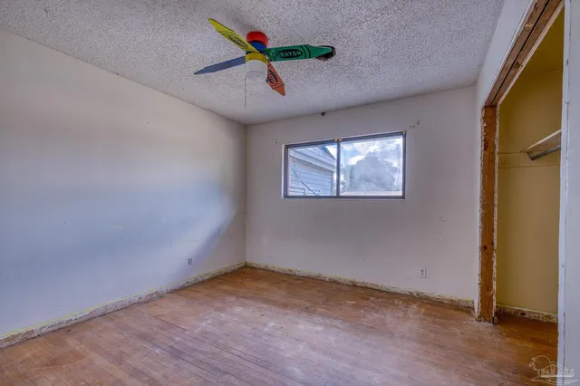 an empty room with closet and a ceiling fan
