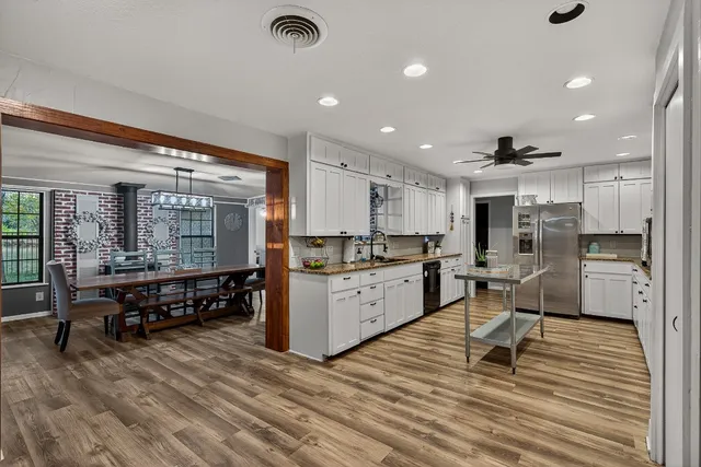 a kitchen with stainless steel appliances kitchen island granite countertop a sink and cabinets