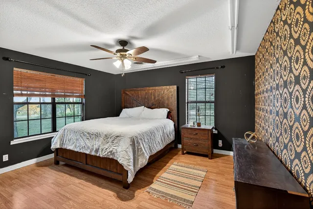 a bed sitting in a spacious bedroom next to a window