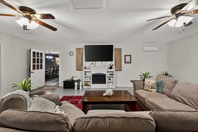 a living room with furniture a fireplace and a flat screen tv