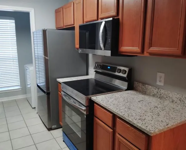 a kitchen with granite countertop a refrigerator and a sink