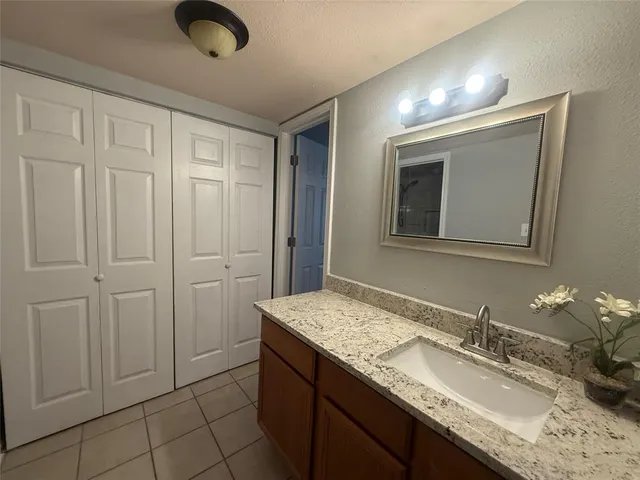 a bathroom with a granite countertop sink and a mirror