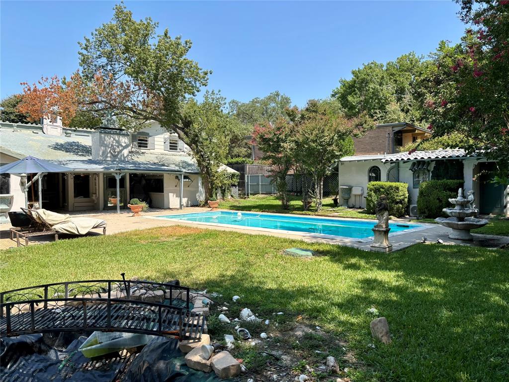 5338 West University Boulevard Dallas, TX 75209 - Photo 1 of 8 a view of a house with swimming pool and yard