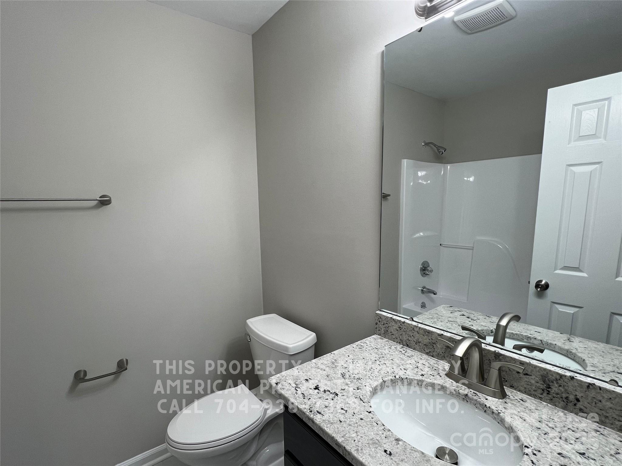 311 Rustic Road Mooresville, NC 28115 - Photo 5 of 10 a bathroom with a granite countertop sink a large mirror and toilet