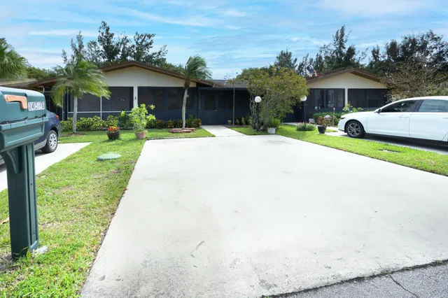 a front view of a house with a yard and trees
