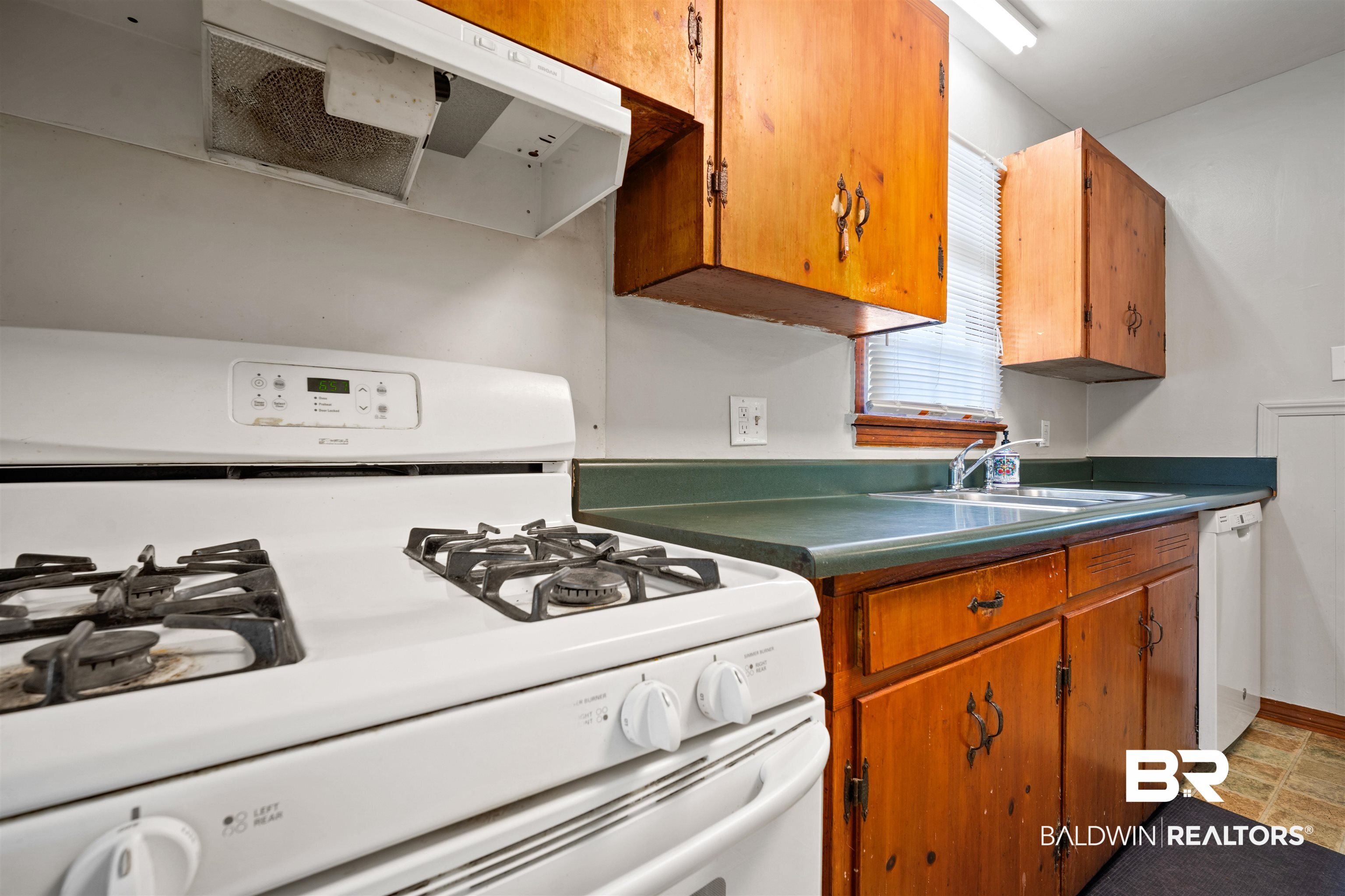 9 Elizabeth Avenue Mobile, AL 36611 - Photo 8 of 19 Kitchen featuring white appliances, exhaust hood, brown cabinets, and dark countertops